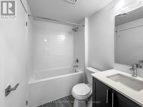 A white bathroom with a toilet, sink, and bathtub.
