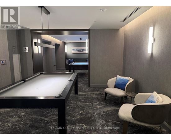 A pool table in a room with Origin Collective Realty.