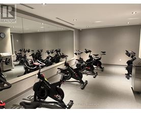 A room full of stationary bikes in front of a mirror.