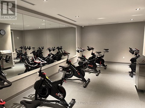 A room full of stationary bikes in front of a mirror.