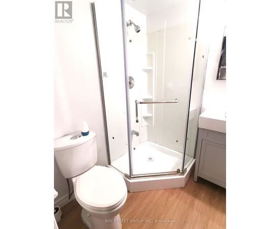 A white toilet sits next to a walk-in shower in a bathroom.