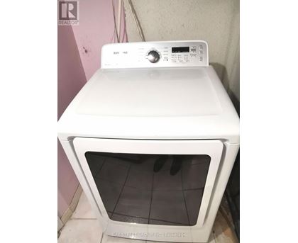 A white Samsung dryer is sitting on top of a white oven.