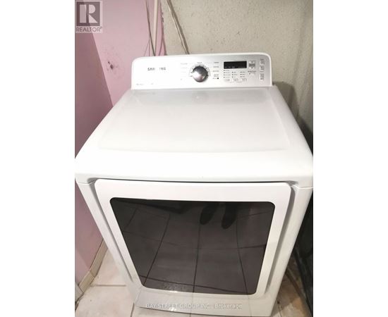 A white Samsung dryer is sitting on top of a white oven.