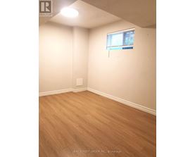 A room with a window and wooden flooring.
