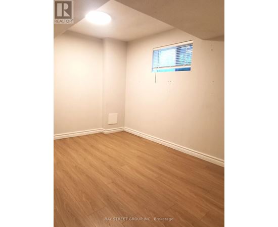 A room with a window and wooden flooring.