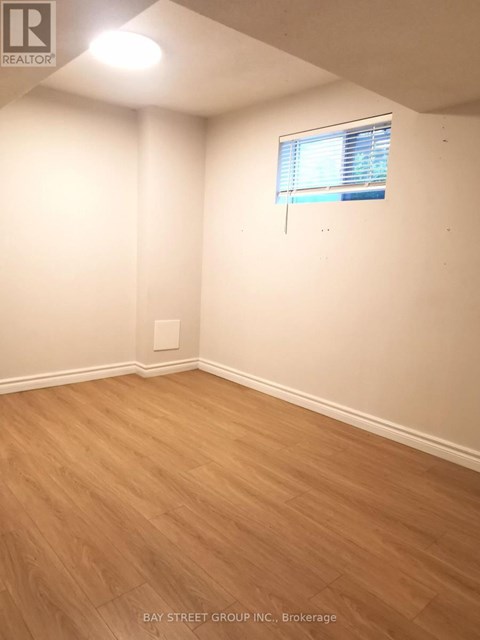 A room with a window and wooden flooring.