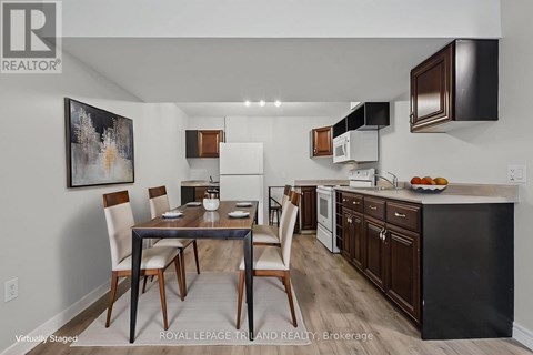 A kitchen with a table and chairs in front of it.
