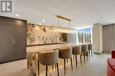 A modern dining room with a stone wall and a long table with chairs.