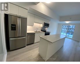 A modern kitchen with stainless steel appliances and a central island.