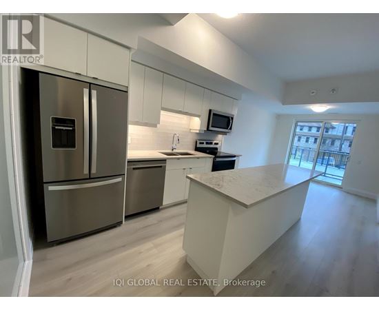A modern kitchen with stainless steel appliances and a central island.