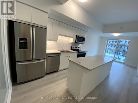 A modern kitchen with stainless steel appliances and a central island.