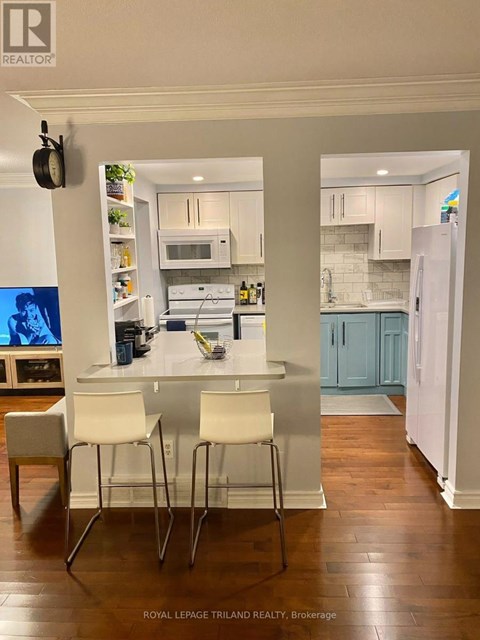 A kitchen with white cabinets and a white fridge.