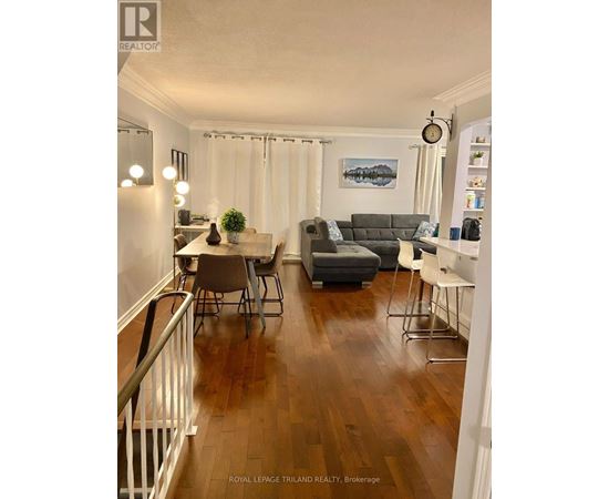 A living room with a grey couch and a painting on the wall.