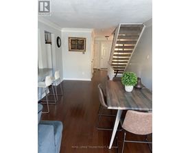 A dining room with a table and chairs.