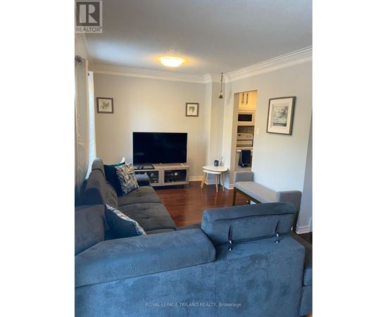 A living room with a grey couch and a television.