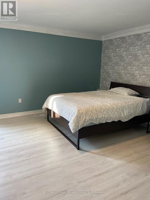 A bedroom with a bed and a brick wall.