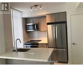 A modern kitchen with stainless steel appliances and a marble countertop.
