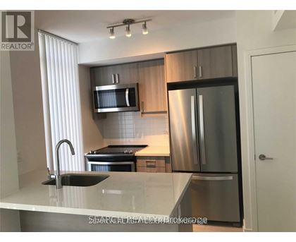 A modern kitchen with stainless steel appliances and a marble countertop.