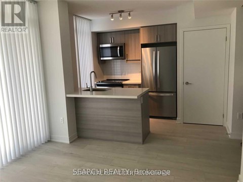 A modern kitchen with a stainless steel refrigerator and a microwave above the stove.