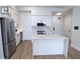 A white kitchen with a refrigerator and a counter.