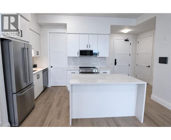 A white kitchen with a refrigerator and a counter.