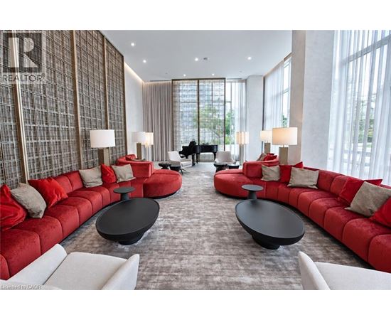 A living room with red couches and a piano.