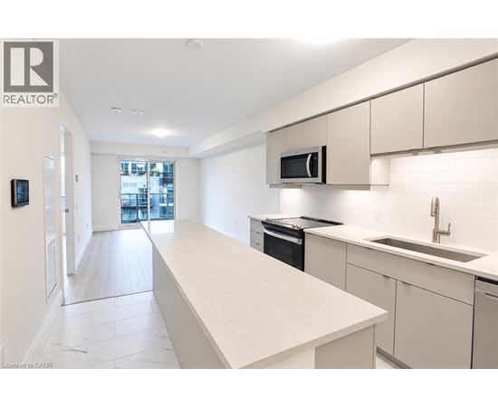 A modern kitchen with white cabinets and appliances.