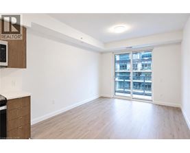 A spacious room with a sliding glass door leading to a balcony.