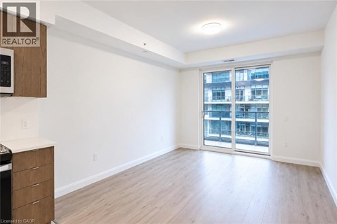 A spacious room with a sliding glass door leading to a balcony.