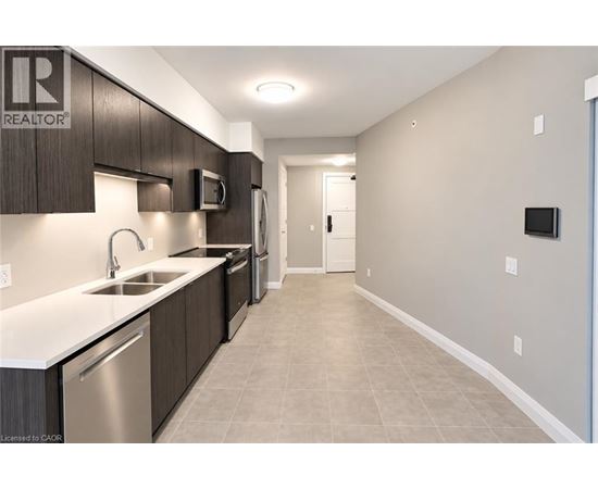A modern kitchen with a sink, microwave, and refrigerator.