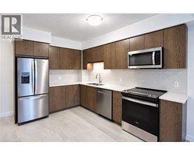 A modern kitchen with wooden cabinets and stainless steel appliances.