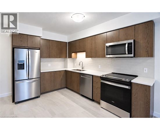 A modern kitchen with wooden cabinets and stainless steel appliances.