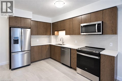 A modern kitchen with wooden cabinets and stainless steel appliances.