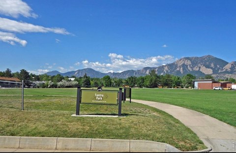 A sign for Tahtra Park stands in a grassy field.