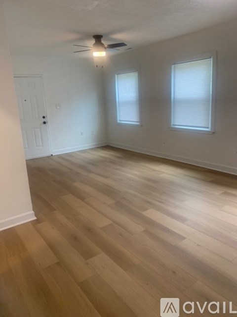 A room with wooden flooring and a ceiling fan.