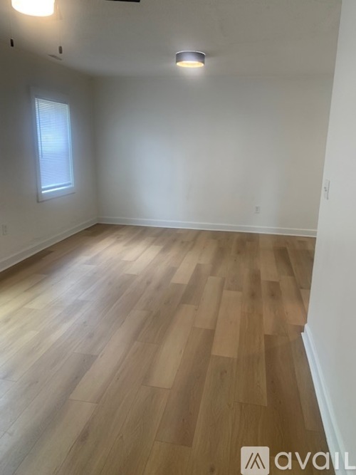 A room with wooden flooring and a window.
