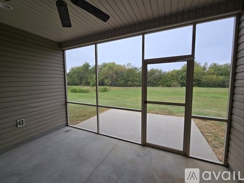 A room with a sliding glass door leading to a grassy area.