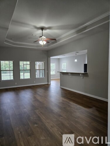 A room with wooden floors and a ceiling fan.