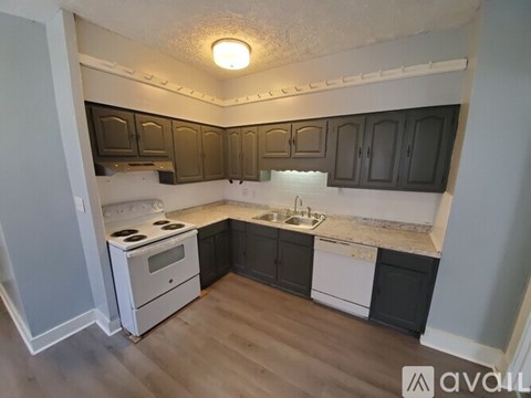 A kitchen with a white stove and black cabinets.
