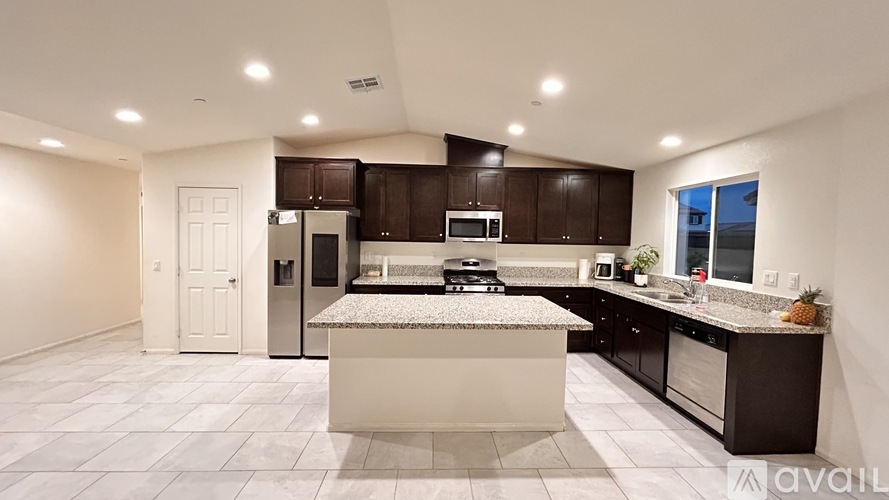 A modern kitchen with dark brown cabinets and a central island.