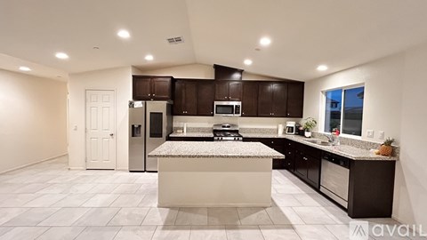 A modern kitchen with dark brown cabinets and a central island.