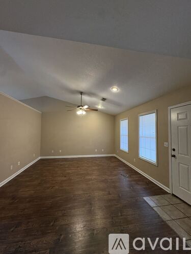 A room with wooden flooring and a ceiling fan.