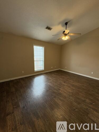A room with wooden flooring and a ceiling fan.