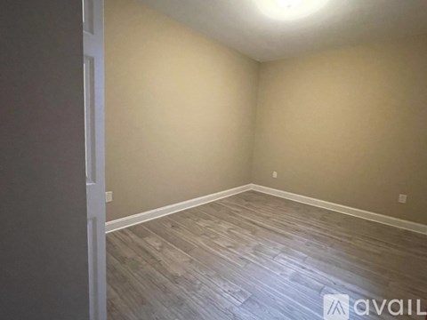 A room with wooden flooring and a white door.