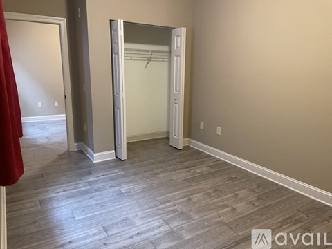 A room with a wooden floor and a white closet.