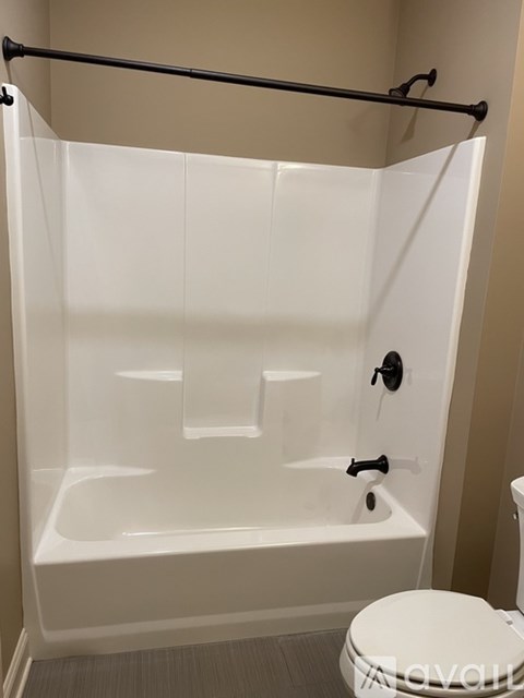 A white bathtub with a toilet in a bathroom.