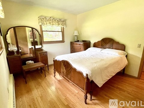 A bedroom with a bed, dresser, and mirror.