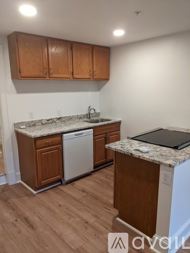 A kitchen with wooden cabinets and a granite countertop.