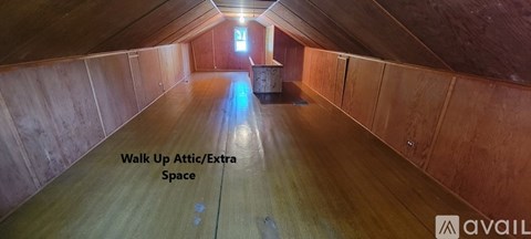 A long, narrow attic space with wooden walls and a skylight.