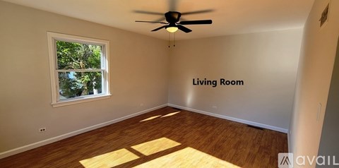 A living room with a ceiling fan and a window.